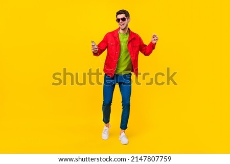 Full body photo of funky young guy dance listen music wear glasses shirt pants sneakers isolated on yellow background