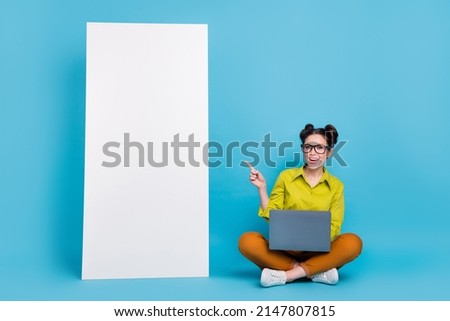 Full size photo of attractive cheerful lady direct finger empty space ui panel isolated on blue color background