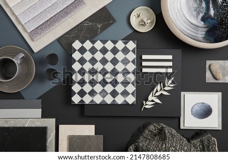 Flat lay of stylish architect moodboard composition with black, beige and grey samples of textile, paint, panels and tiles. Top view. Copy space. Template.