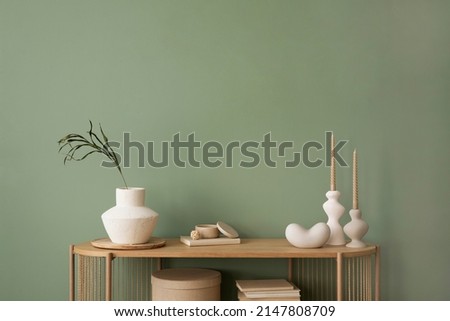 Stylish living room interior design wooden chest of drawers, beige vase and creative home accessories. Sage green wall. Copy space. Template.  Royalty-Free Stock Photo #2147808709
