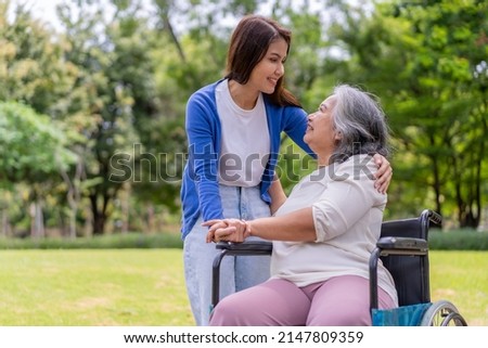 Asian careful caregiver or nurse hold the patient hand and encourage the patient in a wheelchair. Concept of happy retirement with care from a caregiver and Savings and senior health insurance. Royalty-Free Stock Photo #2147809359