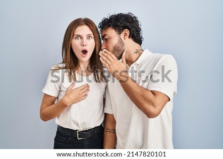 Young couple wearing casual clothes standing together hand on mouth telling secret rumor, whispering malicious talk conversation  Royalty-Free Stock Photo #2147820101