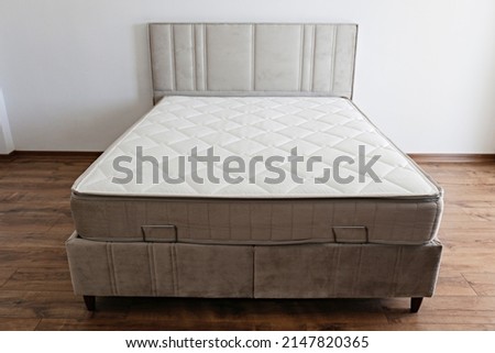White orthopedic mattress top side surface pattern on unmade bed in the bedroom. Hypoallergenic foam matress for proper spinal alignment and pressure point relief. Background, copy space, close up. Royalty-Free Stock Photo #2147820365