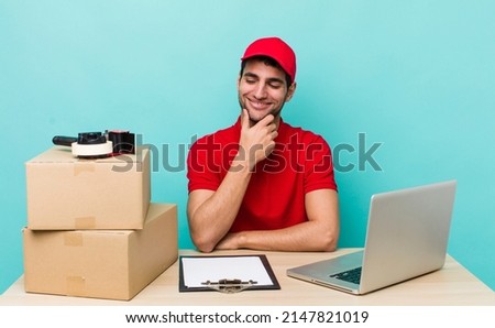 hispanic handsome man smiling with a happy, confident expression with hand on chin. packer employee concept