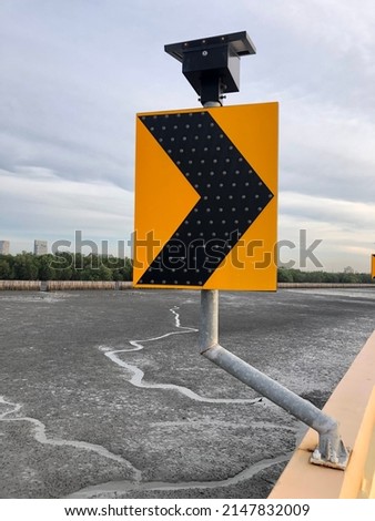 Right chevron traffic sign, the sign warns change direction or warns curve of road.You might see sign on bridge or curve road.The sign will show light when dark sky by solarcell charging with sunlight