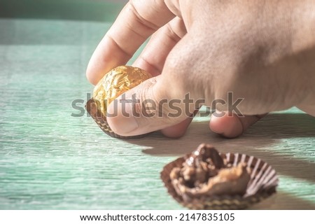 Chocolate with golden anchoring on top of a light green towel..