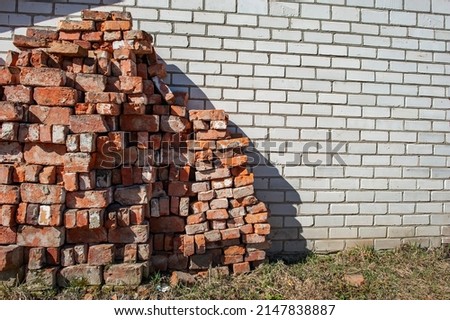 Dismantled wall of a building made of old sand-lime brick against the background of a new wall