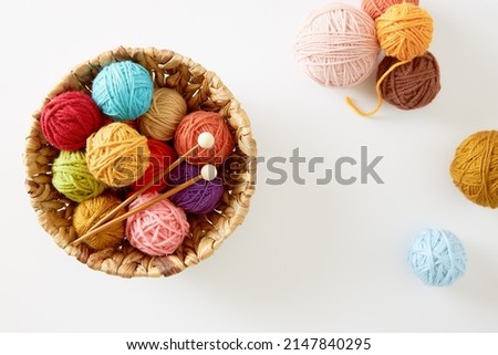 Colorful knitting yarn in a basket on white background. Needlework and hobby. DIY concept. Royalty-Free Stock Photo #2147840295