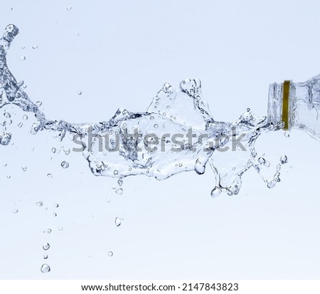 Splash of water from a bottle on a white background. Reflection on the surface of the water. Royalty-Free Stock Photo #2147843823