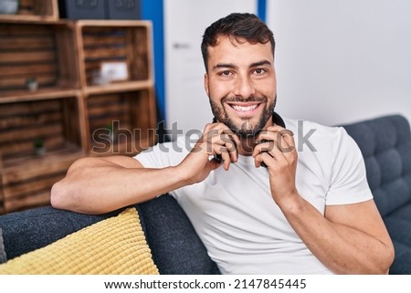 Young hispanic man smiling confident wearing headphones at home