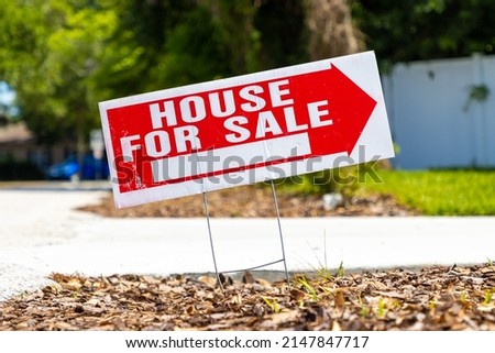 House for sale real estate sign on a street in a neighborhood