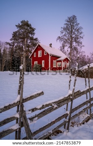 The countryside with a red cottage at the side at winter time