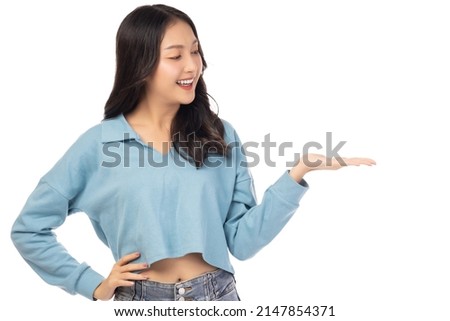 Young asian woman holding copy space imaginary on her palm to insert ad Stand over isolated on white background Portrait happy smiling girl holding copyspace on beauty palm hand with satisfied Royalty-Free Stock Photo #2147854371