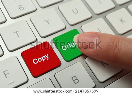 Woman pressing green button with word Original on computer keyboard, closeup. Plagiarism concept Royalty-Free Stock Photo #2147857599