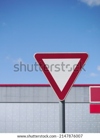 
Vertical shot of a Yield (give way priority) road sign on a metal pole