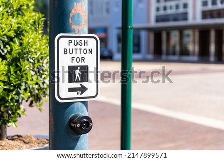 Cross walk sign and button for pedestrians to cross a downtown intersection