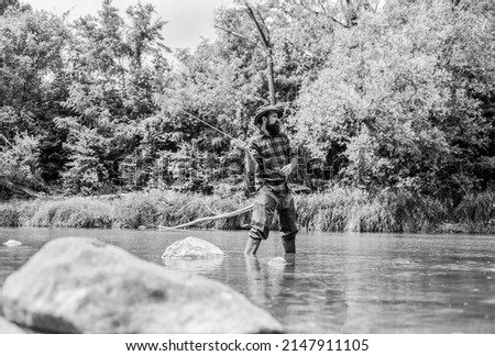 Experience the Legend. experienced fisher in water. man catching fish. mature man fly fishing. fisherman show fishing technique use rod. Successful fly fishing. summer weekend. sport activity hobby