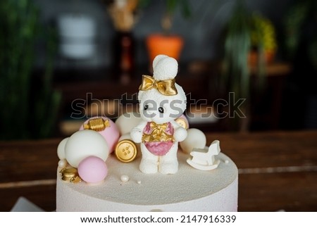 A white chocolate hare decorates a children's birthday cake, a delicious bright cake, a composition of cakes, glaze covers the cake. High quality photo
