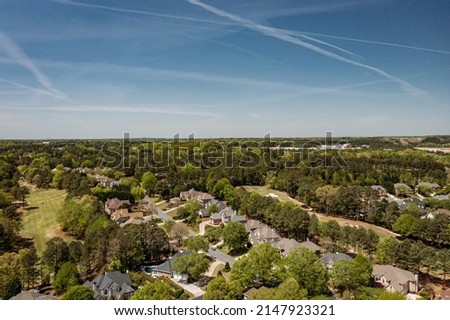 Aerial panoramic view of house cluster in a sub division in Suburbs with golf course and lake in metro Atlanta in Georgia ,USA shot by drone shot during golden hour