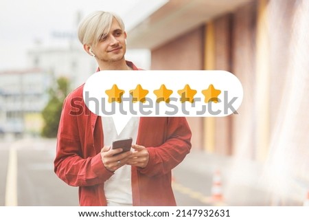 Young hipster giving a 5 star rating on his mobile device.