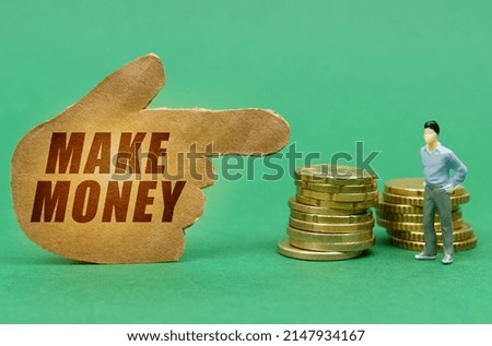 Business and economy concept. On the green surface of the coin and a figure of a man, they are indicated by a sign - a hand with the inscription - MAKE MONEY