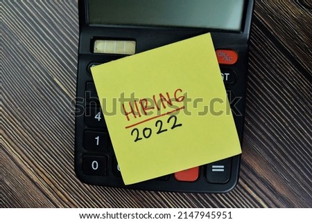 Hiring 2022 write on sticky notes isolated on Wooden Table.