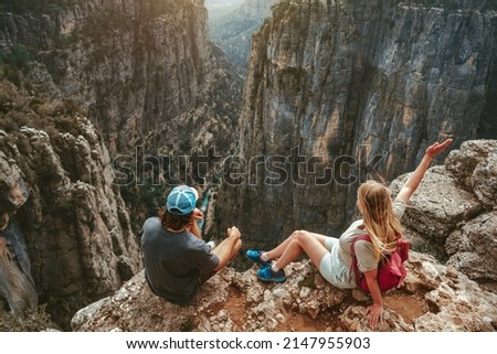Couple hiking together sitting on cliff edge travel healthy lifestyle active vacations outdoor man and woman enjoying Tazi canyon aerial view in Turkey Royalty-Free Stock Photo #2147955903