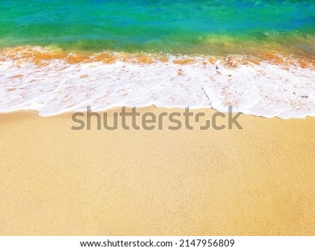 Turquoise blue sea wave on white sand of tropical beach. Soft waves of blue sea and the sand texture of the French West Indies. Wallpaper. Gentle blue ocean wave on a clean sandy beach.