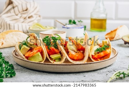Diet healthy tacos with shrimps and avocado on stone background. Selective focus