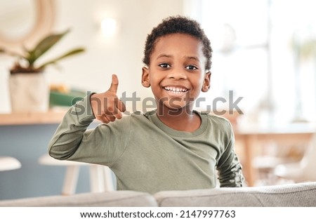 Whos the best boy Me. Portrait of an adorable little boy showing thumbs up on the sofa at home. Royalty-Free Stock Photo #2147997763