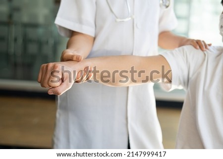 A professional physical therapist is stretching. Patients with musculoskeletal disorders Arm and Elbow Physical Rehabilitation Therapy and conceptual treatment of physiological disorders Royalty-Free Stock Photo #2147999417