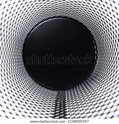 Inside corner, a small black basket made of round steel as a grid. It is used to put the trash, documents that are not working and are overflowing to the outside.