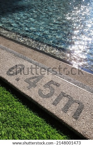 Pool depth warning sign on swimming poll side. Showing swimming pool depth of 0.45 meter. Selective focus image. Royalty-Free Stock Photo #2148001473