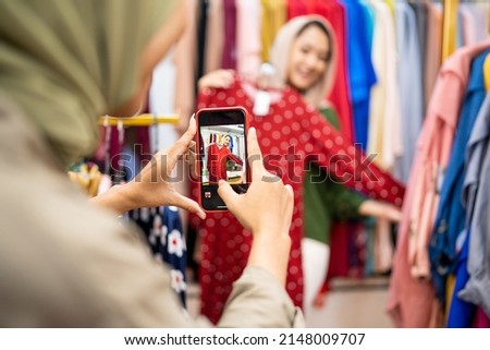 muslim females with head scarf take picture of new dress