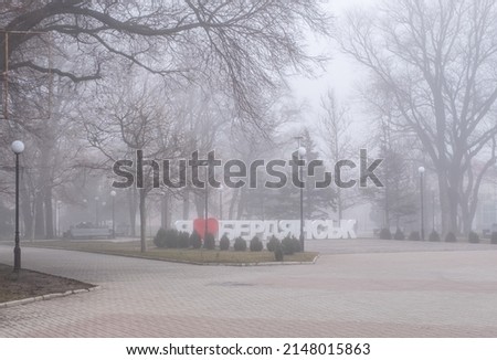 Ukraine, Berdyansk. Fog in the park on the seaside square on a winter day. Translation into English: "I love Berdyansk."