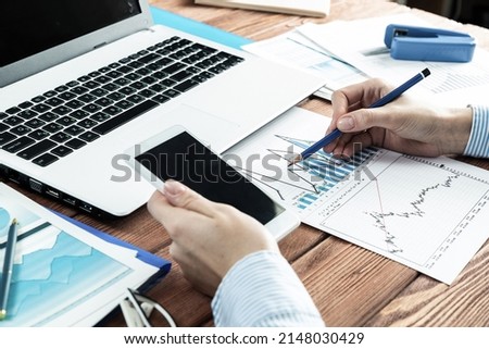 close-up, female hands with phone and chart document. Business woman working at the table in office