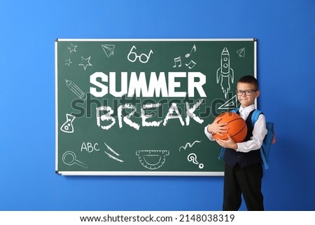 Cute schoolboy with ball near blackboard with text SUMMER BREAK on color background