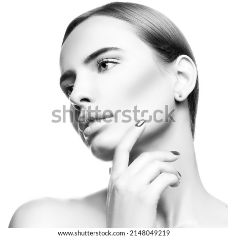 Beauty woman face. Portrait of young beautiful girl touching clean healthy skin. Beauty and skin care concept. Monochrome