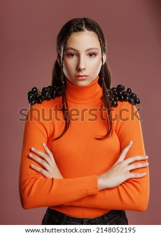  Fashionable teen girl with grapes on the background