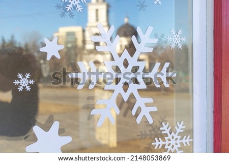 Snowflakes imprinted on the reflecting glass in winter.