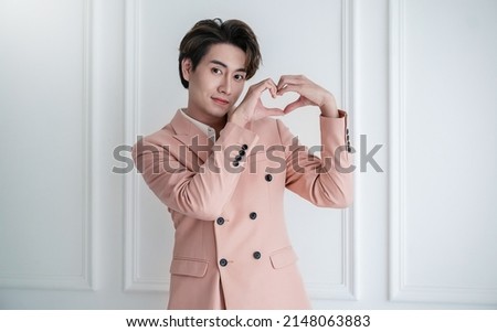 Portrait of young handsome smile asian business man in pink suit hands gesture in heart shape. Smile face asian guy model. Japanese or korean boy lifestyle, happy man valentines day, love concept Royalty-Free Stock Photo #2148063883