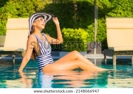 Portrait beautiful young asian woman relax smile leisure on vacation around swimming pool in resort hotel Royalty-Free Stock Photo #2148066947