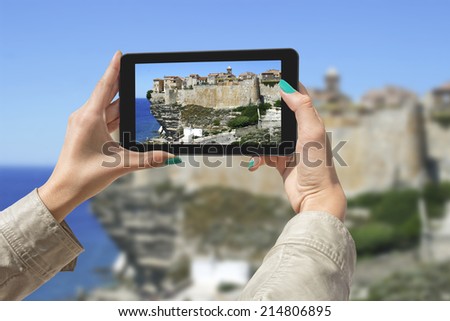 Girl taking pictures on a tablet in Bonifacio, Corsica, France.