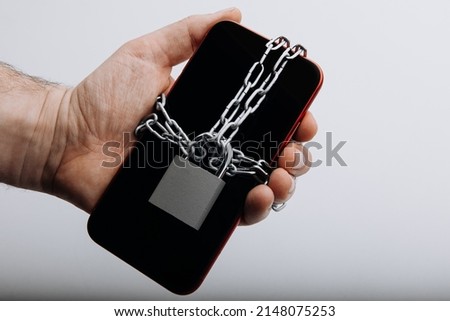 Modern smartphone with chain locked in man's hand. Information security concept