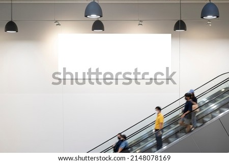 Blank horizontal big poster in public place. Billboard mockup near to escalator in an mall, shopping center, airport terminal, office building or subway station. 