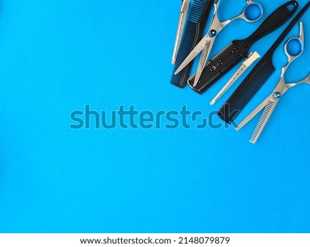 Comb scissors and accessories for hairdressers on blue background. Training hairdressers stylists concept