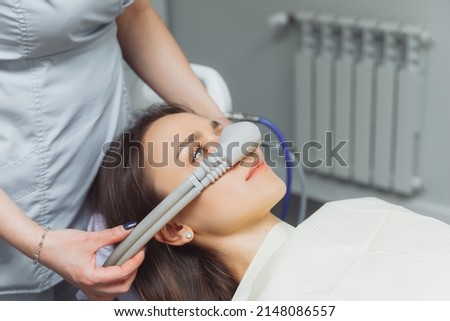 dentist puts inhalation sedative mask on his patient. Royalty-Free Stock Photo #2148086557