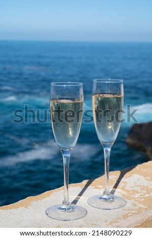New year celebration with two glasses of champagne or Spanish cava sparkling wine and view on blue water of Atlantic ocean, Canary islands, winter tourists destination