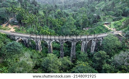 Tourists walk on the famous Nine Arches Bridge at dawn, Ella, Sri Lanka. Aerial Royalty-Free Stock Photo #2148091925