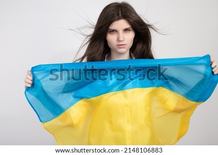 Portrait of serious ukrainian woman with blue and yellow ukrainian flag on a white background.